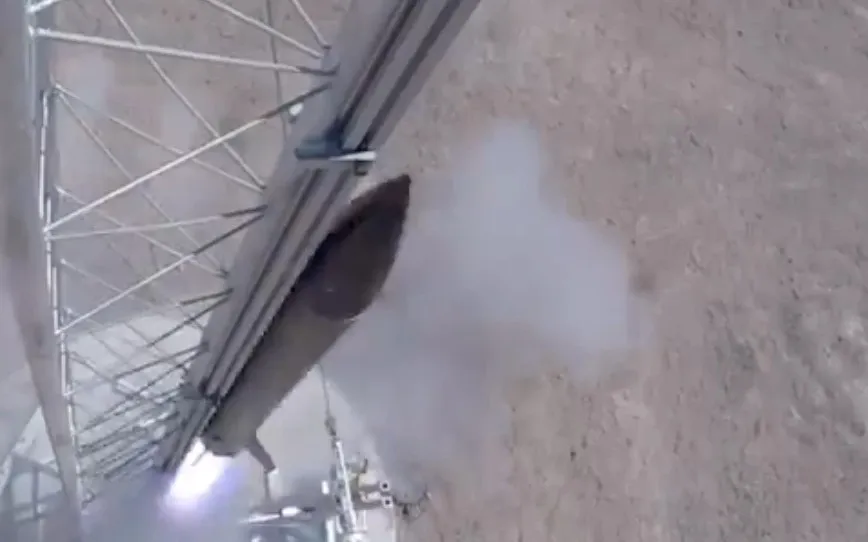 Overhead view of the team's rocket lifting off the launch rail in a cloud of exhaust smoke